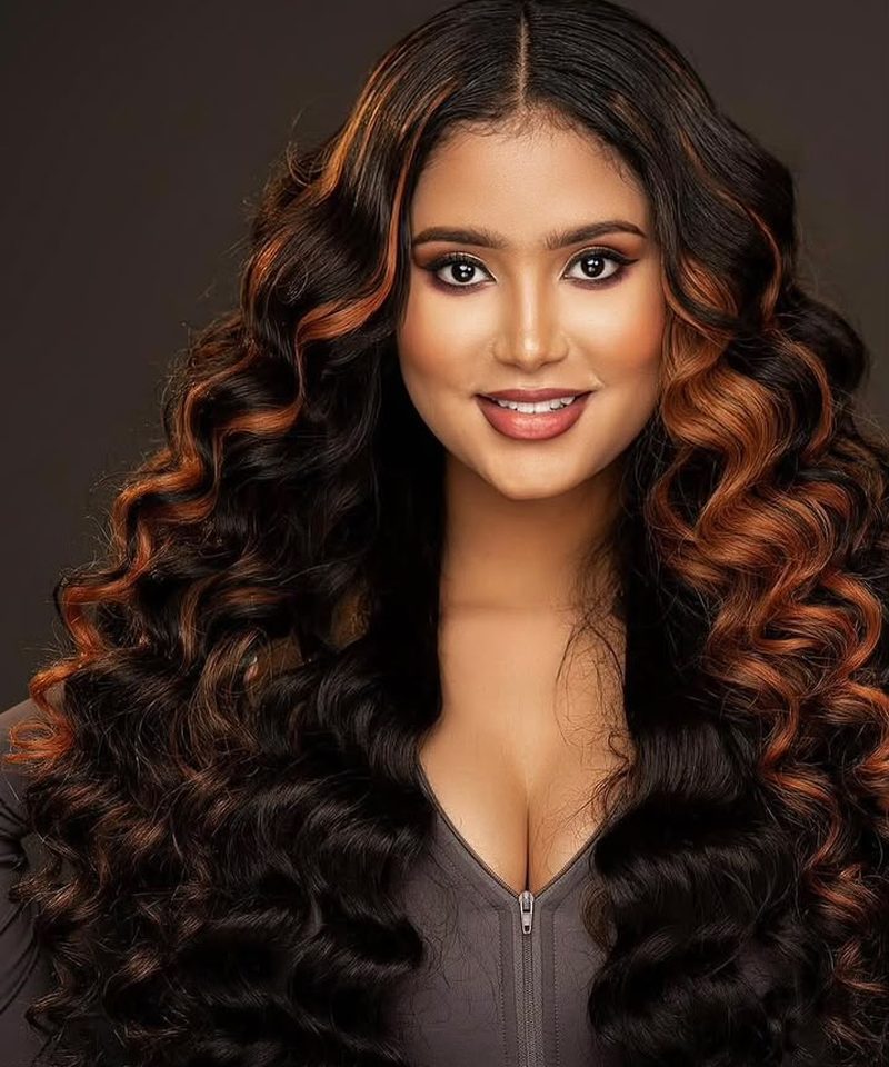 Studio portrait of long copper highlighted curls