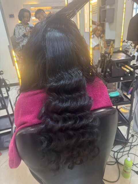 Client getting hair curled in the styling chair at the studio
